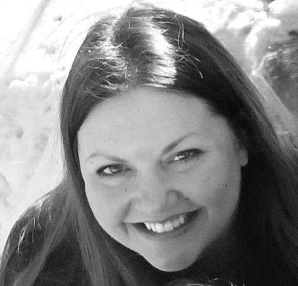 Smiling woman with long dark hair in a black-and-white photo.
