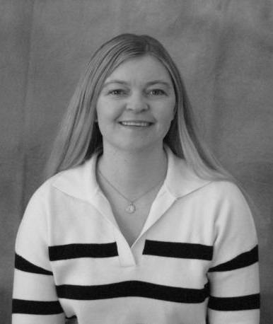 Portrait of a smiling young woman with long hair, wearing a white polo shirt with black horizontal stripes.