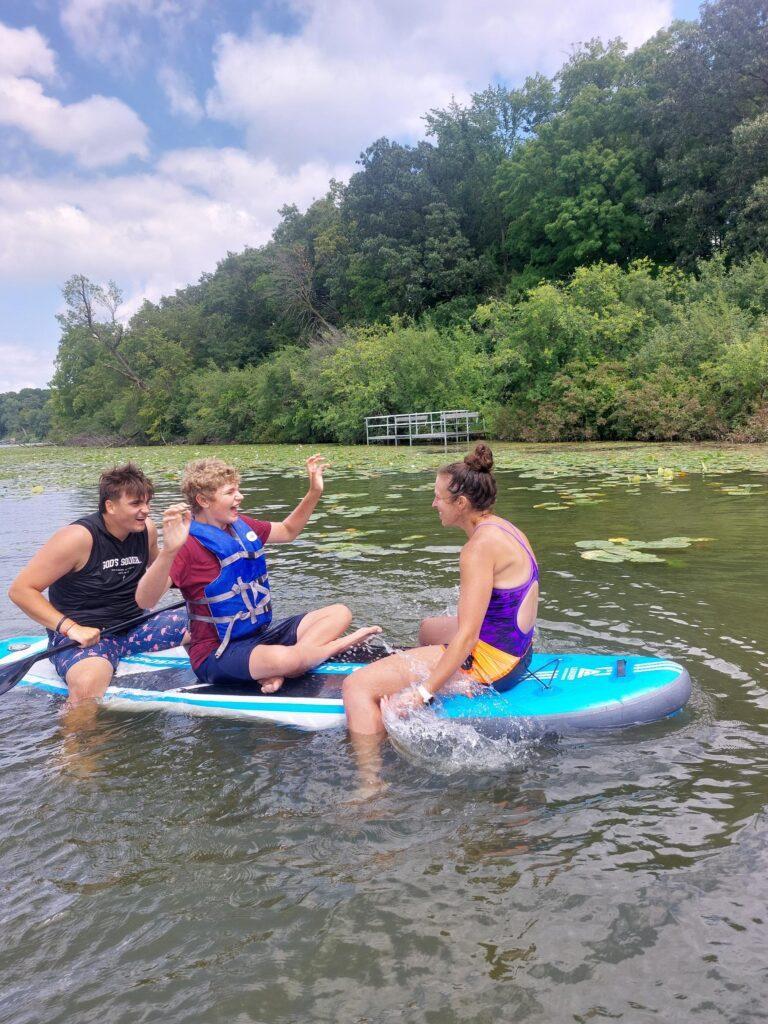 2 boys and a woman on a paddle boat
