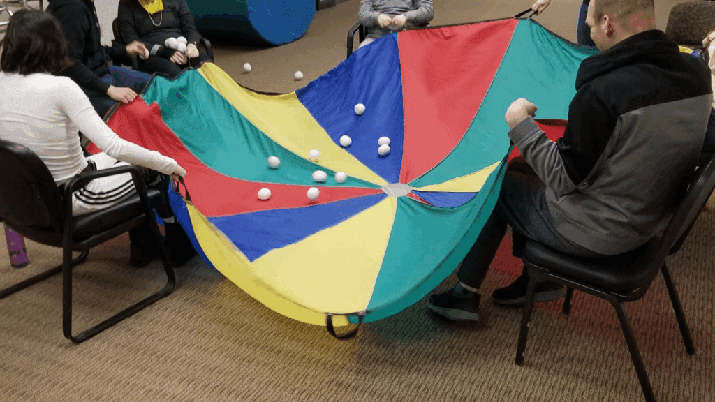Residents use a parachute and balls as an activity